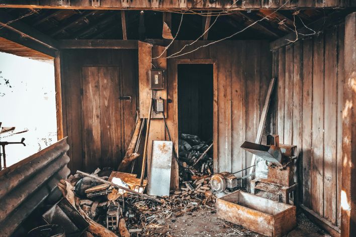Explore the decay of a rustic wooden shed with broken tools and abandoned materials strewn about.