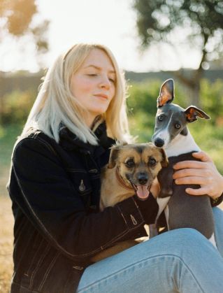A young woman enjoying a day outdoors with her two dogs.