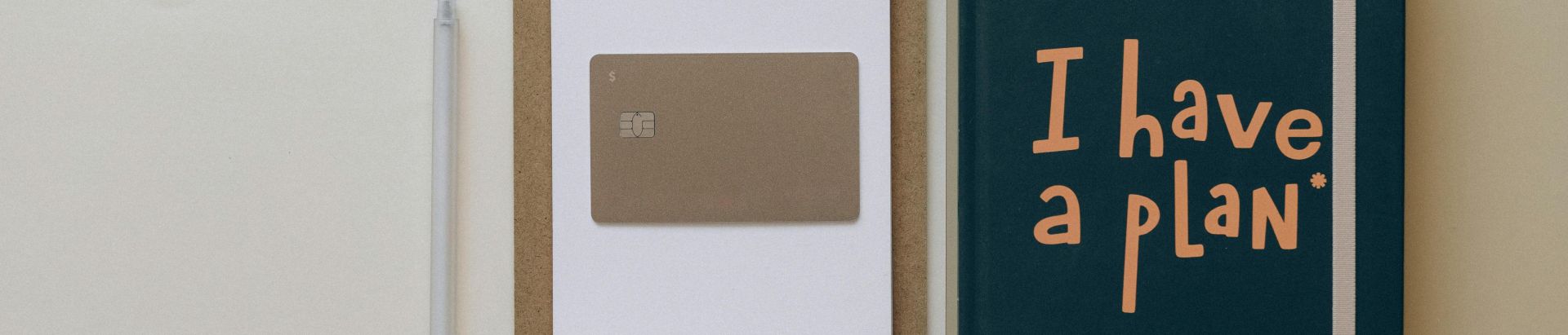 A minimalist office setup featuring a planner, clipboard, card, and pen, perfect for planning and organization.