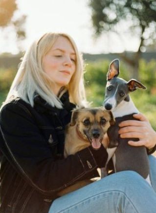 A young woman enjoying a day outdoors with her two dogs.